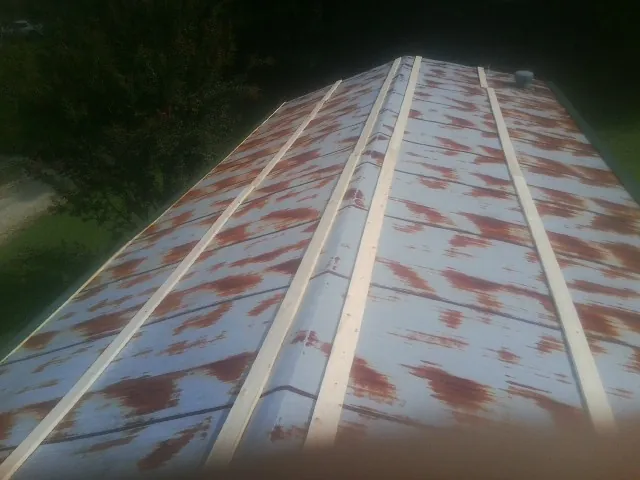 Rusted metal roof panels with new wood purlins before replacement — Storm Damage Roof Repair in Red Creek by Roofing Brothers