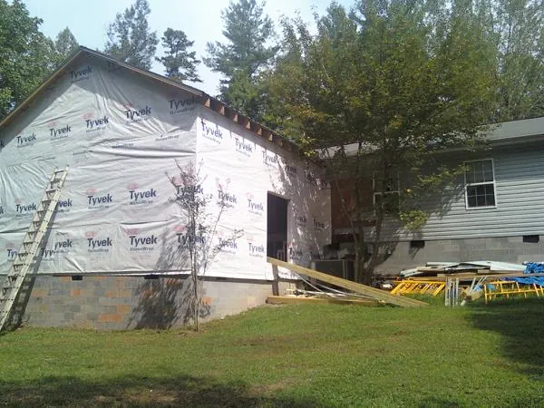 Tyvek wrapped gable on a new room addition beside an existing home in Red Creek