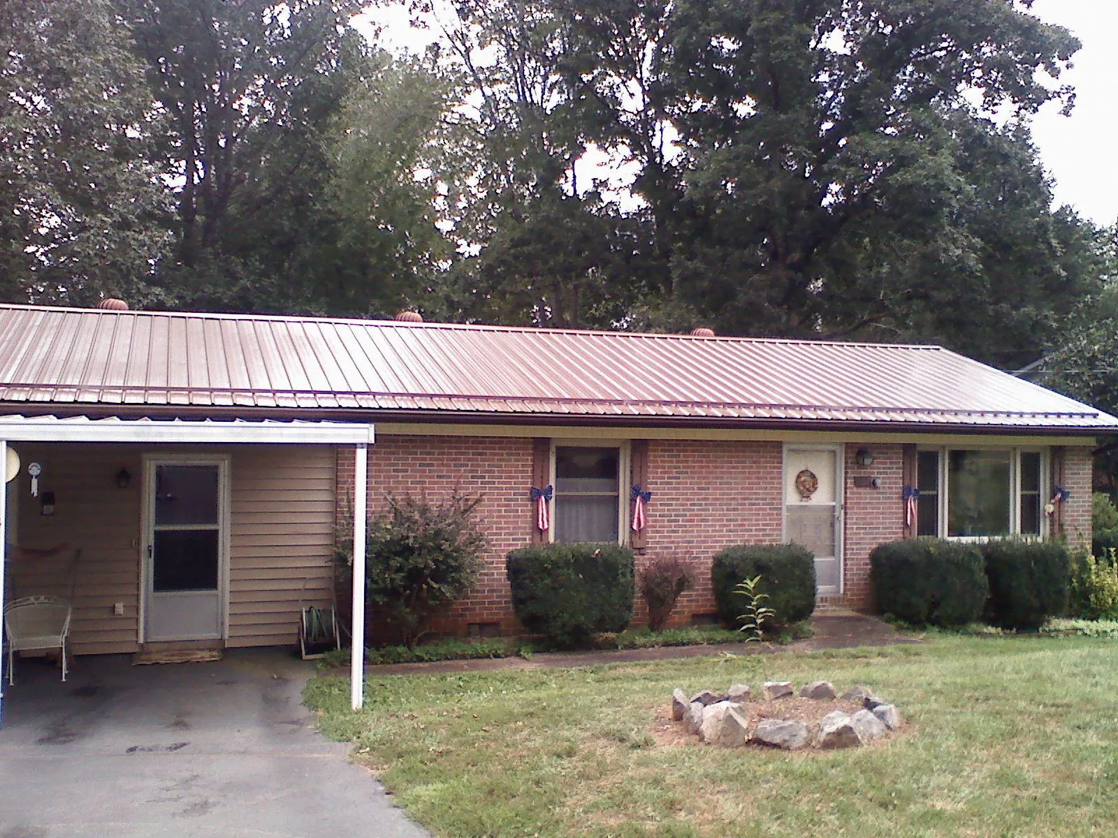 Bronze metal roof and carport on a brick ranch home — Roof Repair work by our crew in Red Creek